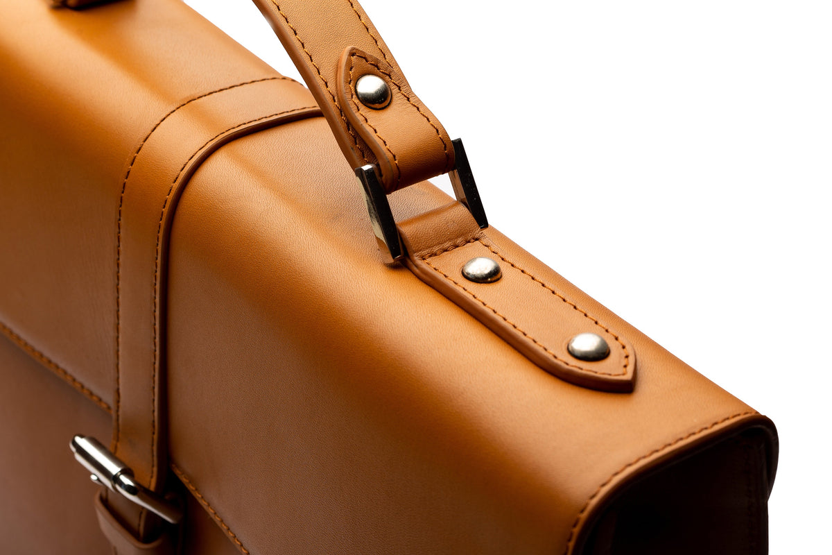 Tan leather laptop briefcase top-down flat lay view