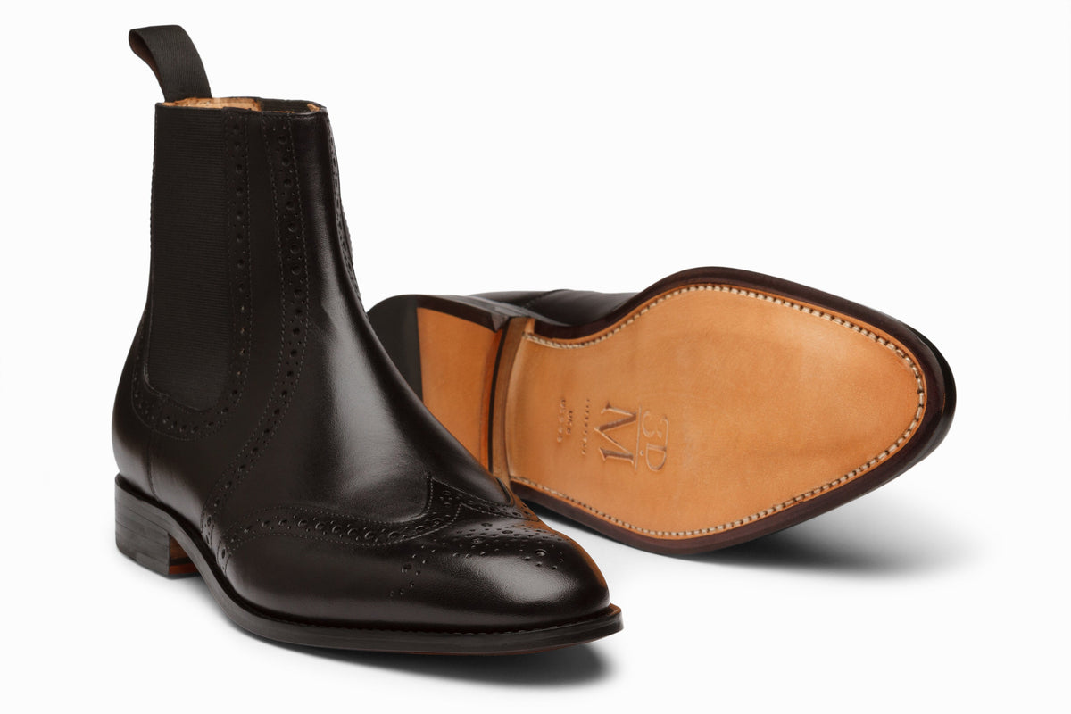 Black wingtip Chelsea brogue boot rear heel view showing elastic gusset