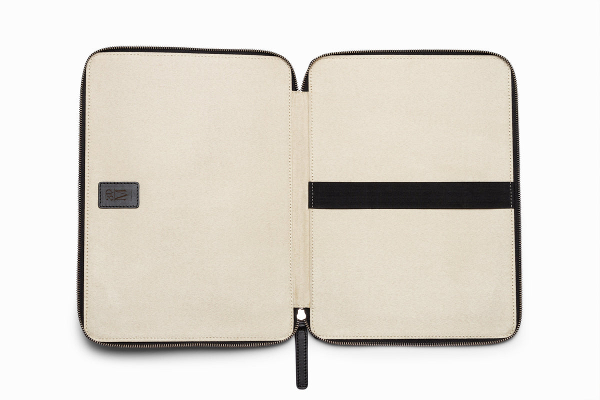 Black leather laptop sleeve top-down flat lay view on neutral background