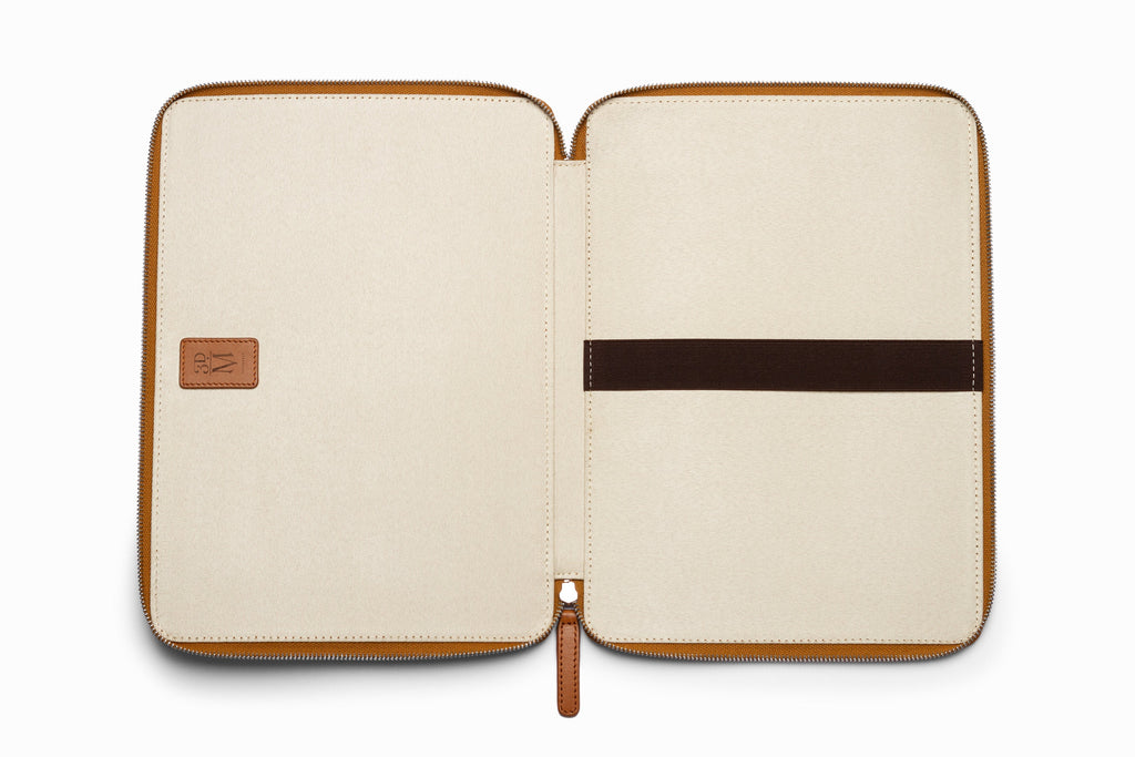 Tan leather laptop sleeve top-down flat lay view on neutral background