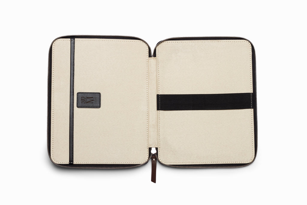 Black leather iPad case top-down flat lay view on neutral background