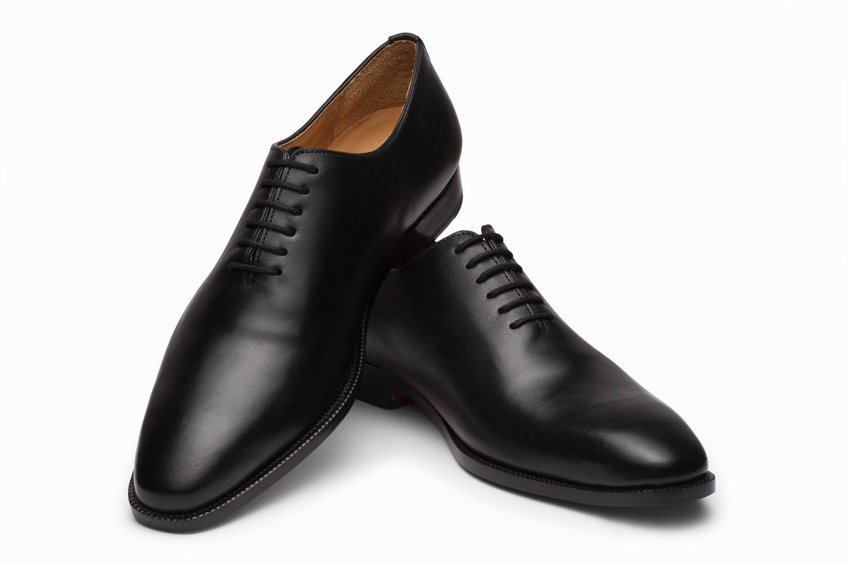 Black wholecut Oxford three-quarter rear view showing seamless leather upper